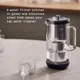Aarke Purifier waterfilterkan van glas en roestvrij staal op aanrecht met glas water