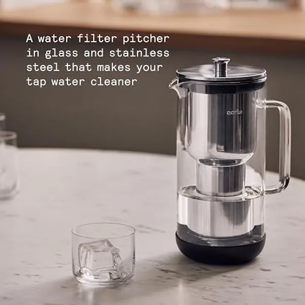 Aarke Purifier waterfilterkan van glas en roestvrij staal op aanrecht met glas water
