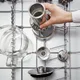 Alle onderdelen van de Aarke Purifier in de vaatwasser: glazen kan, RVS-filter en deksel