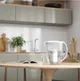 AQUAPHOR Prestige waterfilterkan op keukentafel met glas gefilterd water