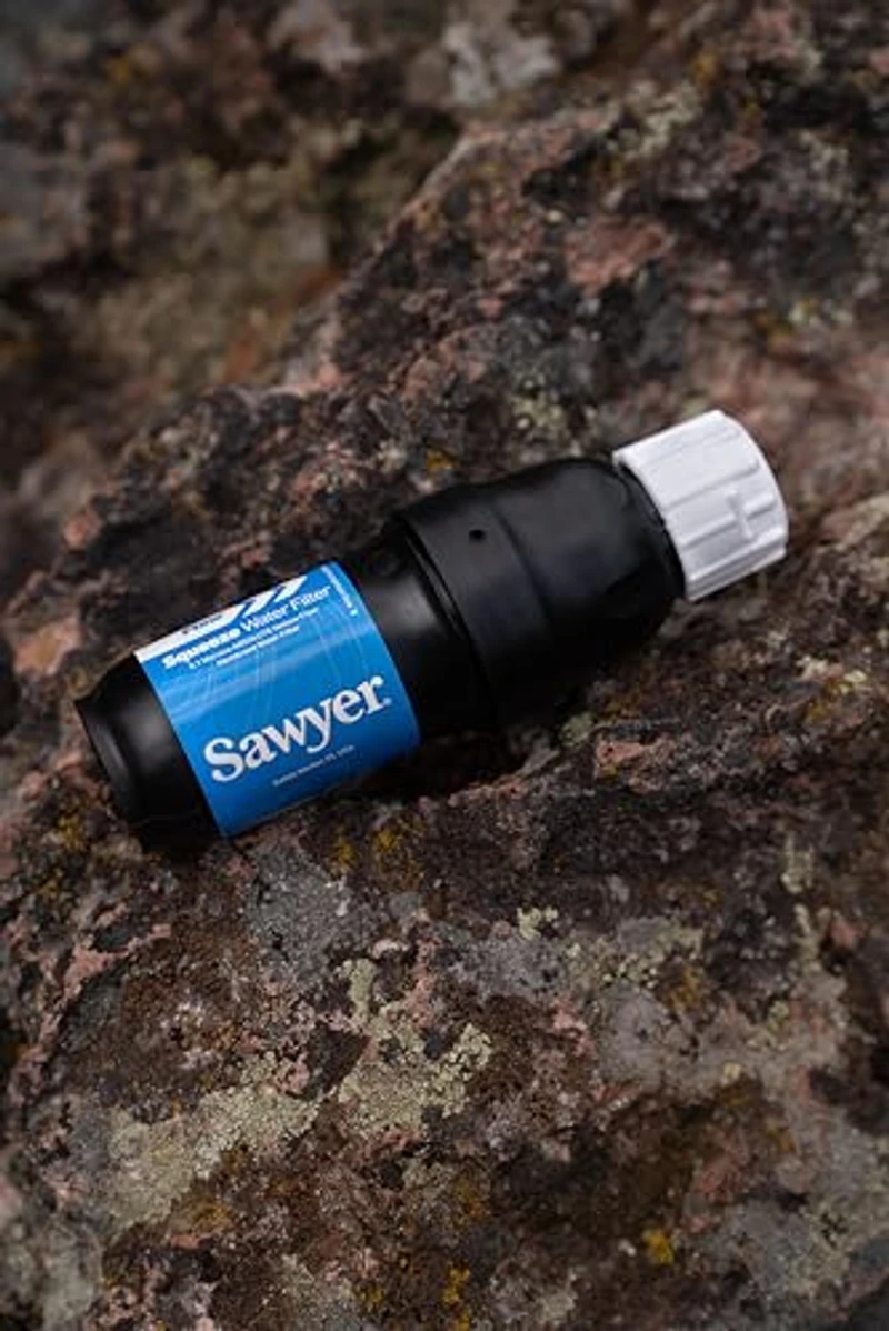 Sawyer Squeeze filter close-up op een rots, compact zwart ontwerp met blauwe label