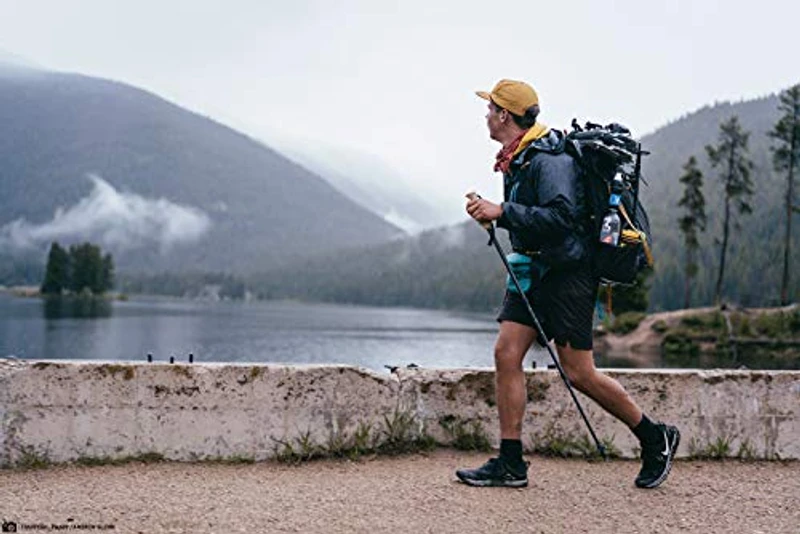 Backpacker met Sawyer Squeeze aan rugzak lopend langs een bergmeer