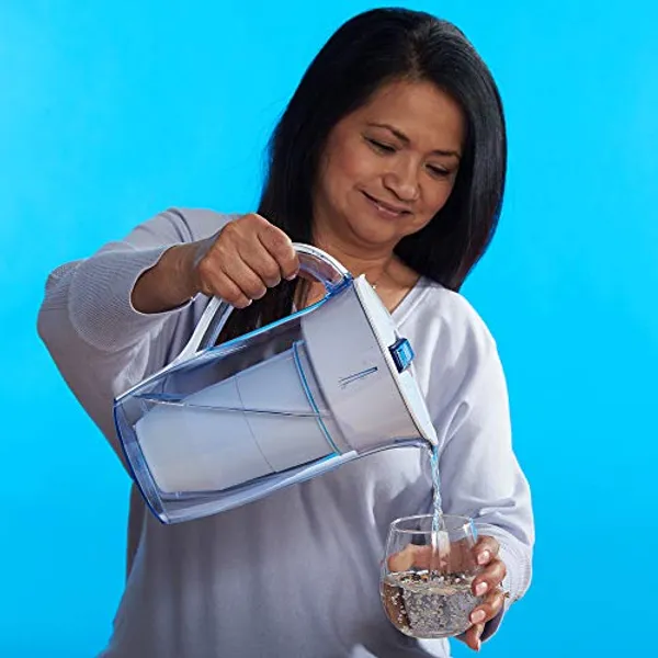 Vrouw schenkt gefilterd water uit ZeroWater ronde 2,4 liter kan in een glas
